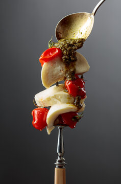 Mozzarella with pesto sauce and roasted red cherry tomatoes.