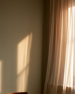 Sunlight curtain shadow wall window soft warm minimal interior morning sun casts warm sunlight through sheer curtain onto plain wall, creating soft shadow and tranquil minimal interior mood