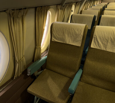 View of seats inside an old passenger plane showing retro style
