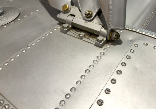 Close-up of silver metal machine with rivets, bolts and hinges 
