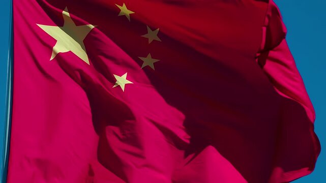 Chinese Flag Waves the Wind. The Big State Flag is illuminated by the sun and flutters epically in the wind against the blue sky