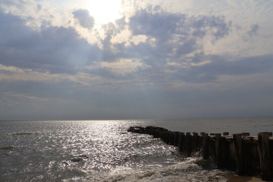 A old nautical looking jetty sitting out on a placid bay during a peaceful summer evening.