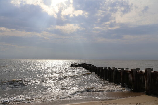 A old nautical looking jetty sitting out on a placid bay during a peaceful summer evening.