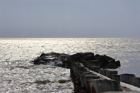 A old nautical looking jetty sitting out on a placid bay during a peaceful summer evening.