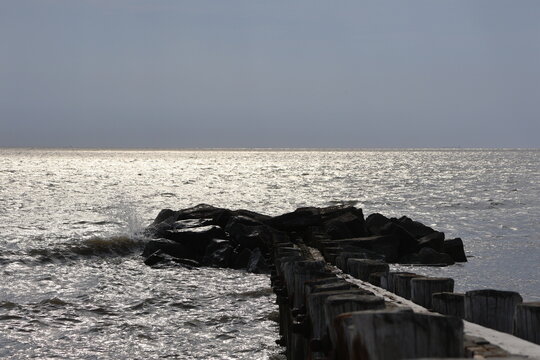 A old nautical looking jetty sitting out on a placid bay during a peaceful summer evening.
