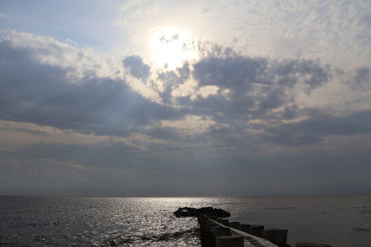 A old nautical looking jetty sitting out on a placid bay during a peaceful summer evening.
