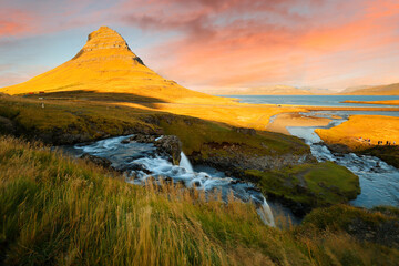Obraz premium Mt. Kirkjufell and Kirkjufellsfoss waterfall at Sunset, Iceland. The fall also known as Church Mountain Falls located at Kirkjufell mountain on the west side of Iceland.