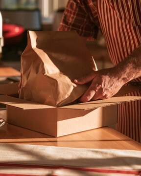 Delivery packaging cardboard box paper bag shipping courier parcel small business male hand delivery packaging cardboard box paper bag shipping courier parcel small business male hand warm sunset