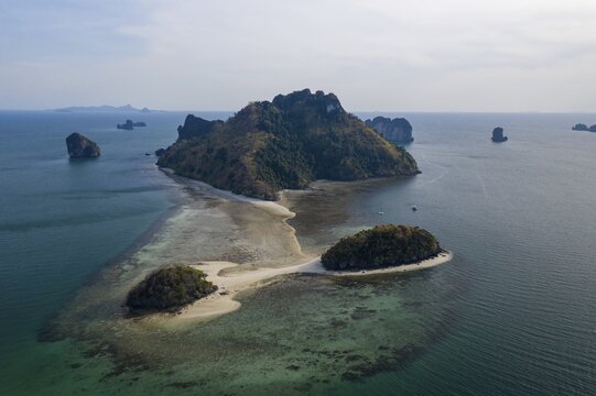 Aerial view, Tropical island at sunset with offshore reef and two smaller islands, Koh Po da Nok Island, Krabi Province, Thailand