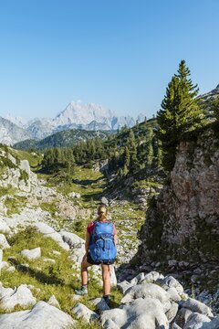 Hiker mit Rucksack looks into the distance, hiking trail in the Funtenseetauern, behind Watzmann, National Park Berchtesgaden, Berchtesgadener Land, Upper Bavaria, Bavaria, Germany