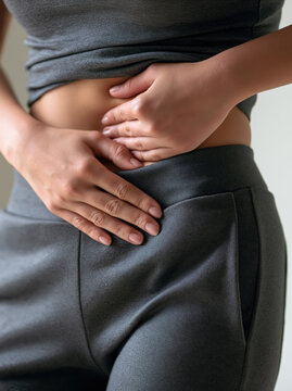 Woman stomach pain cramp abdomen health fitness discomfort injury stress Woman stomach pain cramp abdomen health fitness discomfort injury stress concept showing close up hand pressing side belly