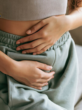 Woman stomach pain cramp period menstruation health abdomen discomfort female belly symptom medical digestion ache anxiety stress sick unwell hand casual clothing indoor home lifestyle body skin