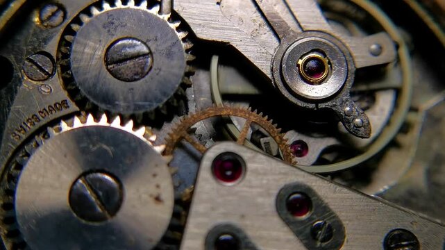 High quality macro footage of an authentic Swiss made mechanical watch movement operating, showing oscillating balance wheel, ruby jewels, steel gears, and Swiss Made engraving.