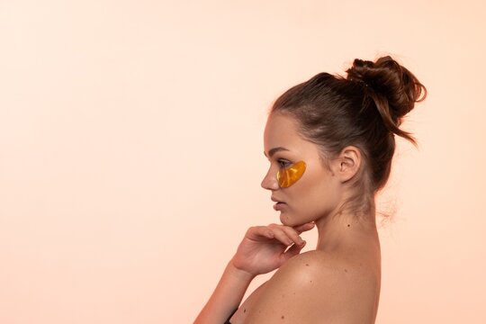 Young woman applying golden eye patches for under eye skincare treatment and beauty wellness