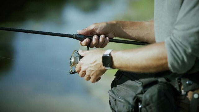 Fisherman Holding Spinning Fishing Rod And Reeling Line. Outdoor Hobby 