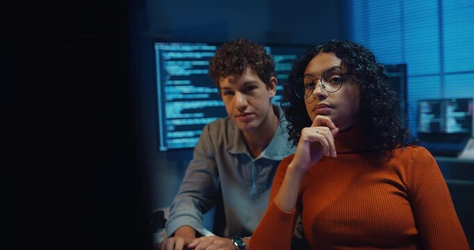 Diverse team software developer discuss AI coding project strategy in dark office at night. Creative startup group brainstorming, Mentor code review training, Digital communication innovation concept.