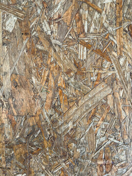 Weathered osb board texture with layered wood chips and strands, authentic rustic oriented strand board surface for construction background or design use. 