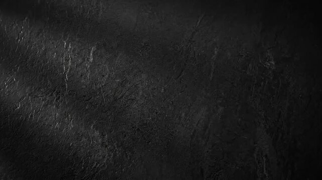 Dark textured concrete wall background with subtle shadows moving