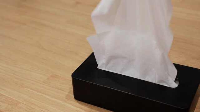 Slow motion of tissue rising from a black tissue box