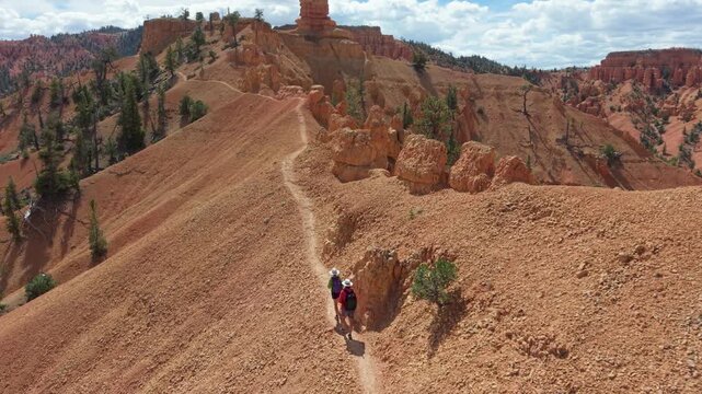 Aerial views of man and woman hiking along the Buckhorn trail near Bryce Canyon, Utah, surrounded by hoodoos and open landscape.