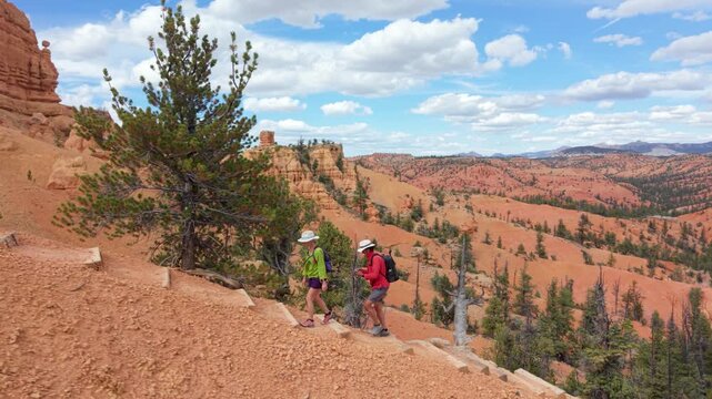 Aerial views of man and woman hike along the Buckhorn trail in Bryce Canyon, Utah, surrounded by unique hoodoos and beautiful landscapes.