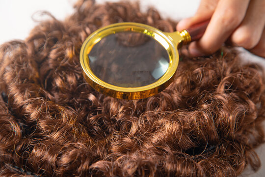 Male hand magnifying beautiful wig.