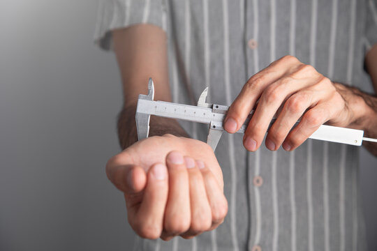 Man with a caliper measuring hand.