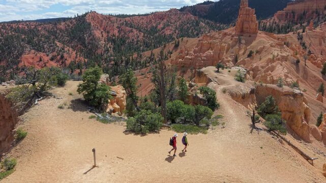 Aerial view of man and woman hiking on the Buckhorn trail surrounded by unique rock formations in Bryce Canyon, Utah, enjoying the natural scenery