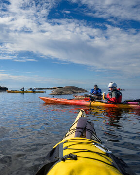 First person sea kayak view of paddlers in a red tandem kayak on Georgian Bay, Ontario, copy space, vertical format, portrait orientation, mobile ready