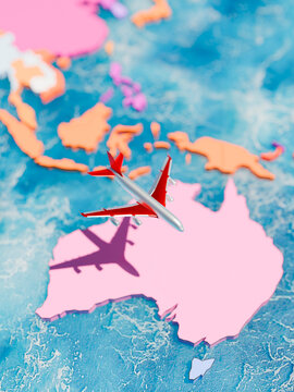 Red airplane flying over a stylized 3D map of Australia and the surrounding ocean region