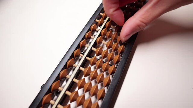 Slow-motion fingers calculating on an abacus.