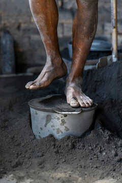 Bare feet resting on an aluminum pot, Ambatolampy, Madagascar