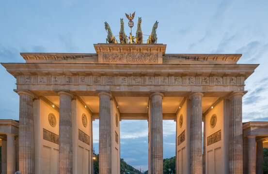 View of the Brandenburg Gate with its neoclassical columns and the Quadriga statue at dusk in Berlin, Berlin, Germany.
