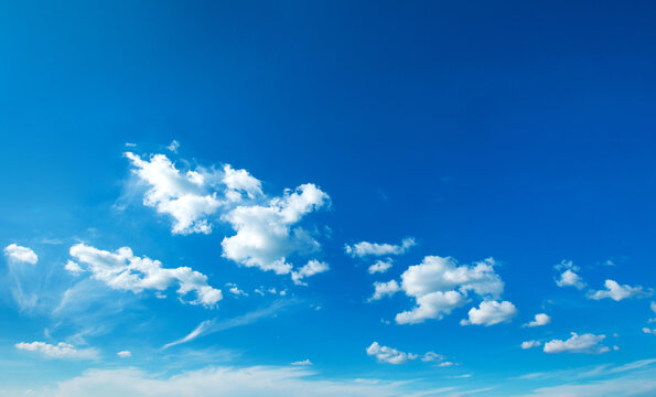 blue sky. white fluffy clouds with rainbow in the blue sky