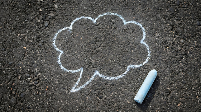 White chalk cloud speech bubble drawn on asphalt pavement road with chalk piece