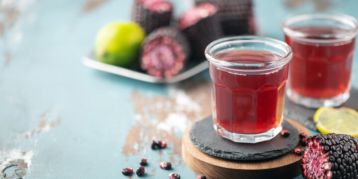 Chicha morada. Purple corn juice in glass on wooden table. Sweet traditional peruvian drink