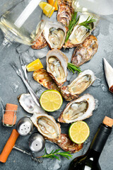 Composition of wine, glasses and fresh open oysters. Healthy sea food. on a gray textured stone background. Free space for text. © Yaruniv-Studio