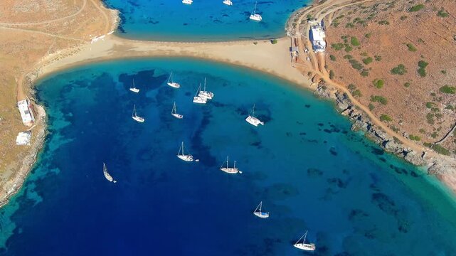 Aerial view of Simos Beach with turquoise water and sailboats anchored in the bay in Islands, Greece.