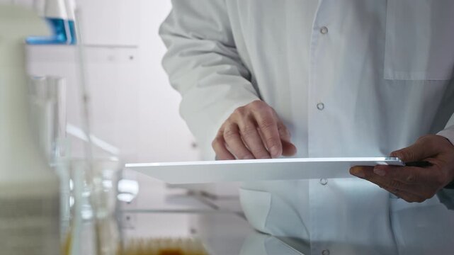 Close-up researchers working in a medical laboratory. Taking research notes on modern tablets