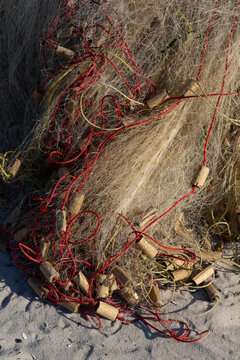 Fishing net with wooden weights on sand, Belo sur Mer, Madagascar