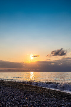 dark blue sky with setting sun over sea and beach