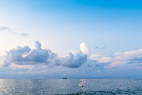 blue sky with low clouds in over sea water at dusk