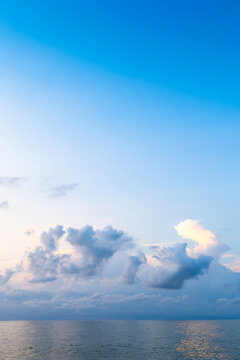dark blue sky with cumuli clouds in over calm sea