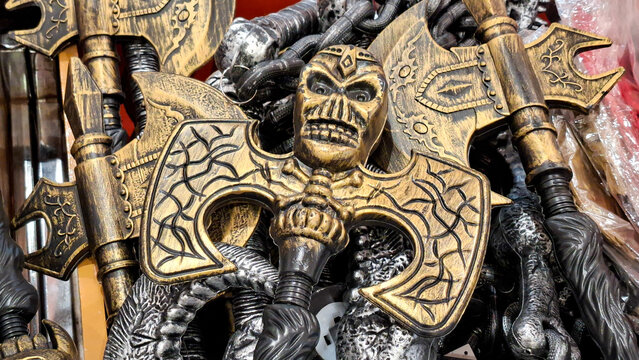 Golden plastic medieval battle axe prop with skull detail and carved patterns for Halloween costume accessory