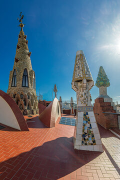 BARCELONA, SPAIN - APRIL 14, 2024: Original chimneys covered with ceramics of different colors on the roof of the Palau Guell designed by architect Antoni Gaudi. Built 1886-1888, UNESCO.