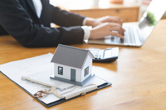 Real estate, banker present house model with client before tenant sign contract rental purchase buyer home with landlord, realtor after agreement mortgage success done. Property lease agent concept.