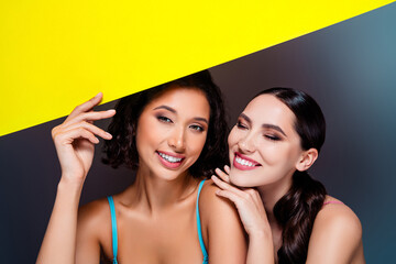 Two friends smile together in a bright studio fashion portrait showcasing beauty and friendship © Beauty Hero