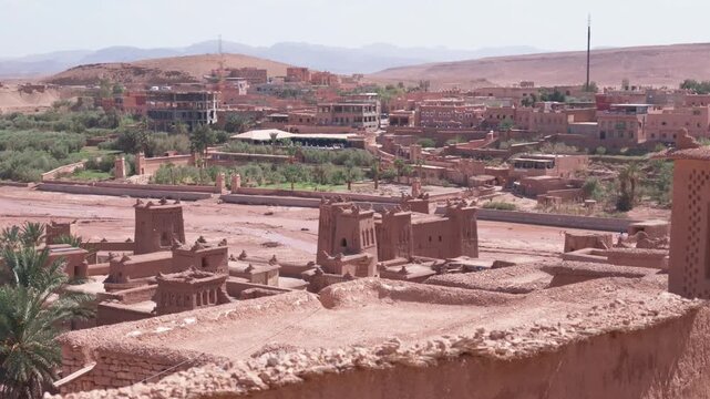 Scenic panoramic view of the ancient ksar of ait-ben-haddou in morocco with its traditional mud-brick kasbahs and the atlas mountains in the background