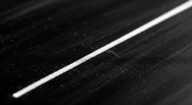 Single thin diagonal white line cutting through textured black dark background with soft cinematic monochromatic lighting mood