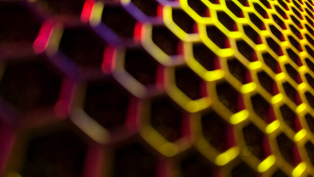 Abstract illuminated hexagonal grid representing digital data flow, network structure, and technology innovation with vibrant yellow and magenta lights